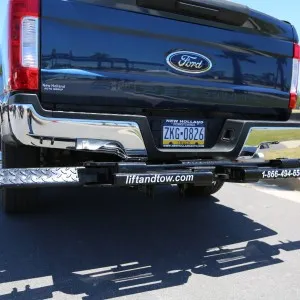 Hidden tow boom under a pickup truck